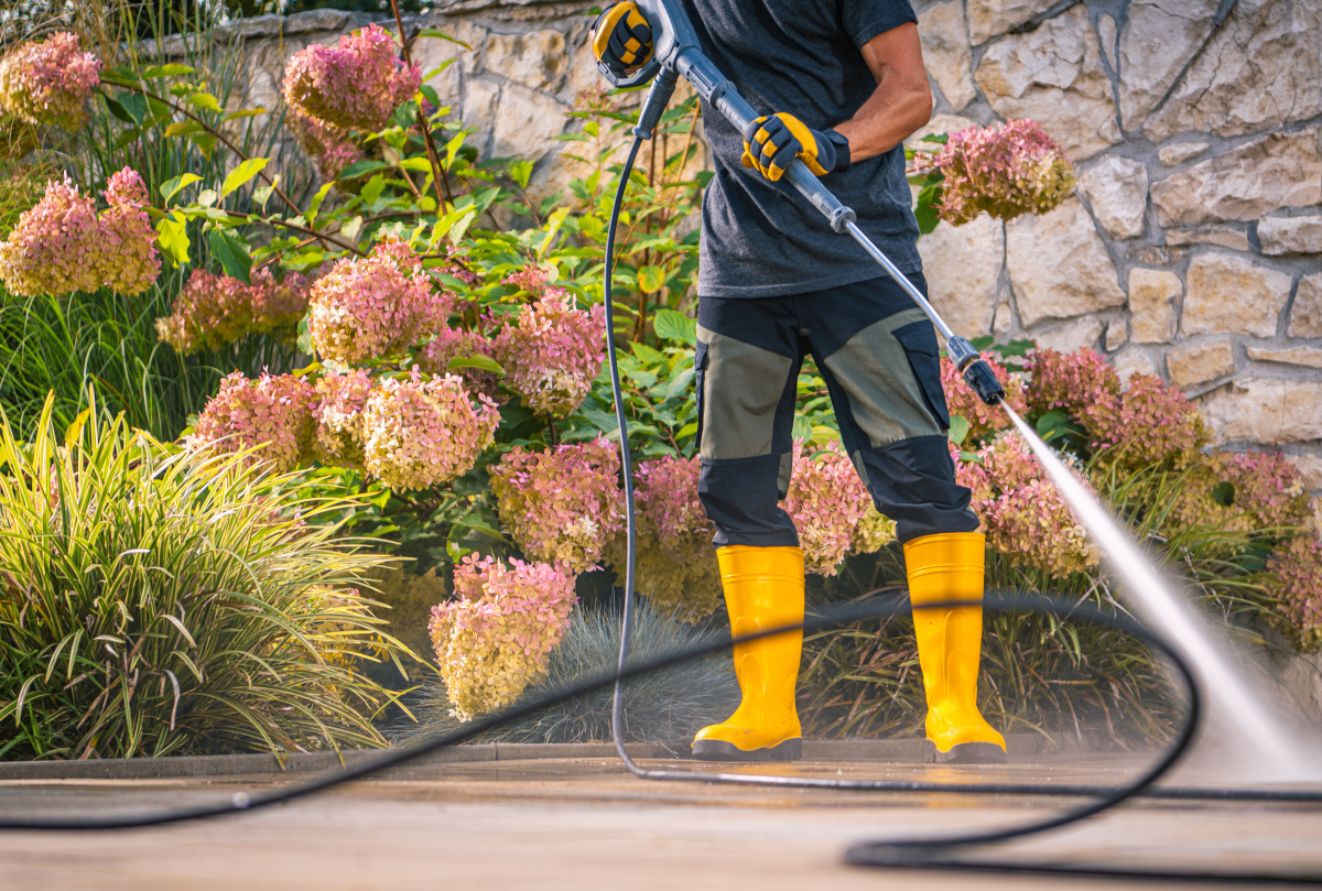 Technician cleaning exterior window as final touch on pristine home exterior
