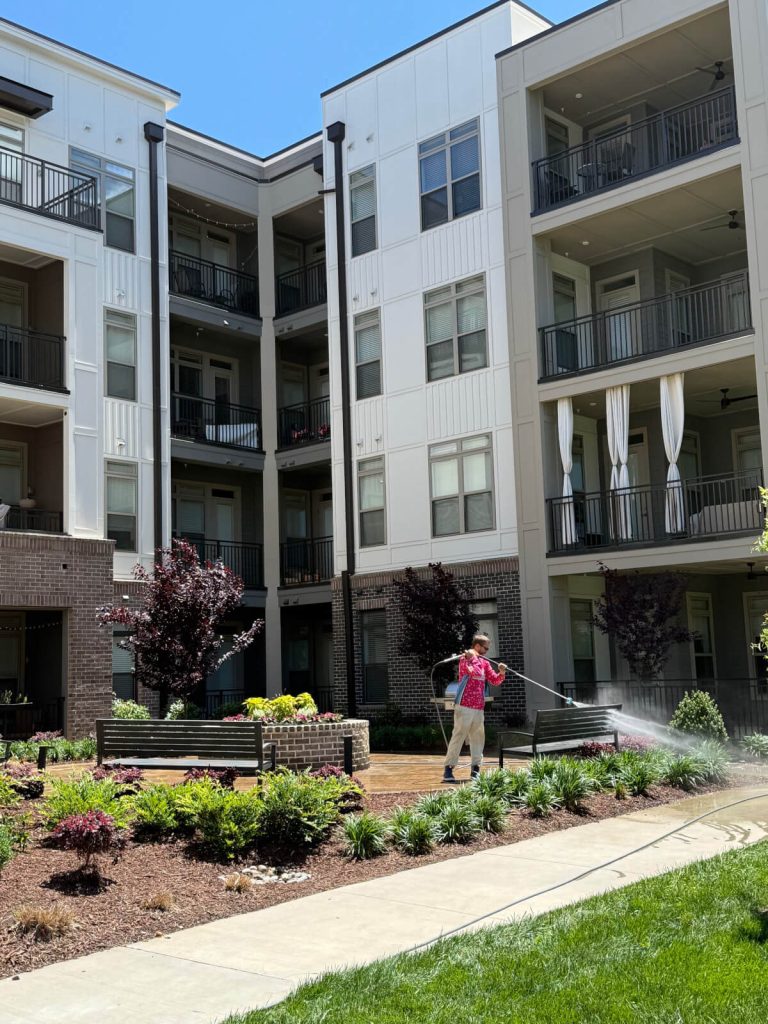 Charlotte Exterior Services team member pressure washing apartment complex exterior and pool deck in Charlotte NC