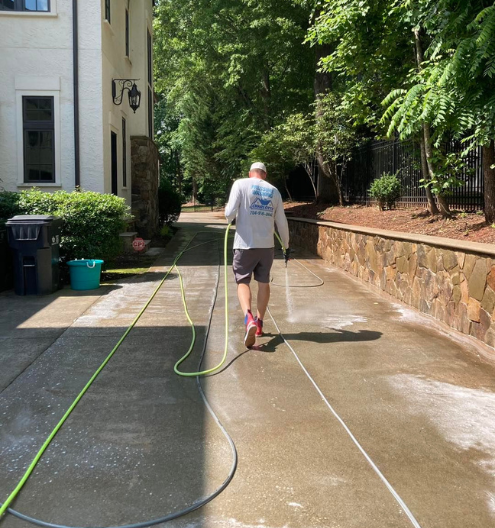 Charlotte Exterior Services technician pressure washing driveway in Charlotte NC