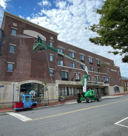 Commercial pressure washing company cleaning brick storefront in Charlotte NC - pressure washing hotel