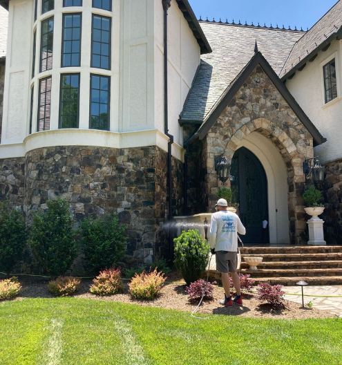Beautiful luxury home with rock extrerior being cleaned by luxury home pressure washing company Charlotte Exterior Services in Charlotte NC