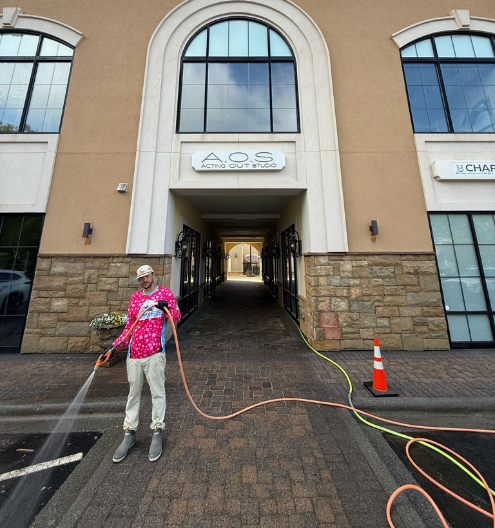 Charlotte Exterior Service team member sidewalk pressure washing at Charlotte retail strip mall